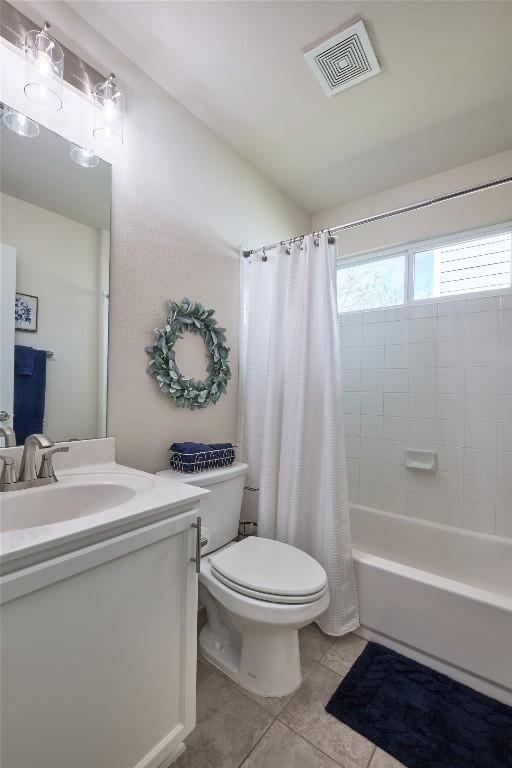 full bathroom with visible vents, toilet, shower / bath combo, tile patterned flooring, and vanity