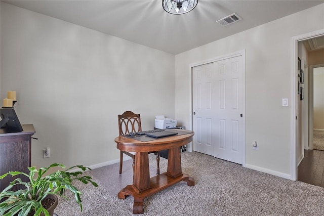 carpeted office space featuring baseboards and visible vents