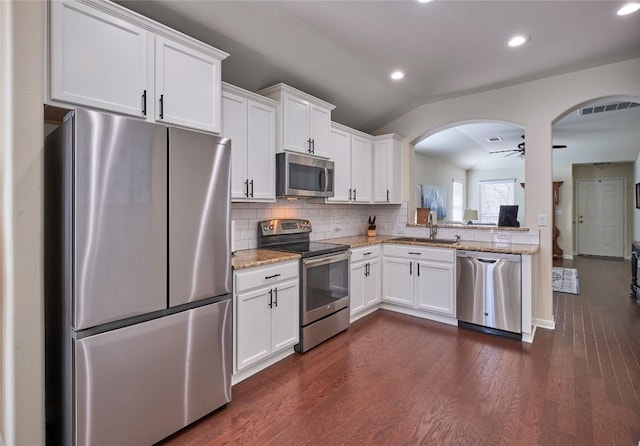 kitchen with a sink, tasteful backsplash, dark wood-style floors, white cabinetry, and stainless steel appliances