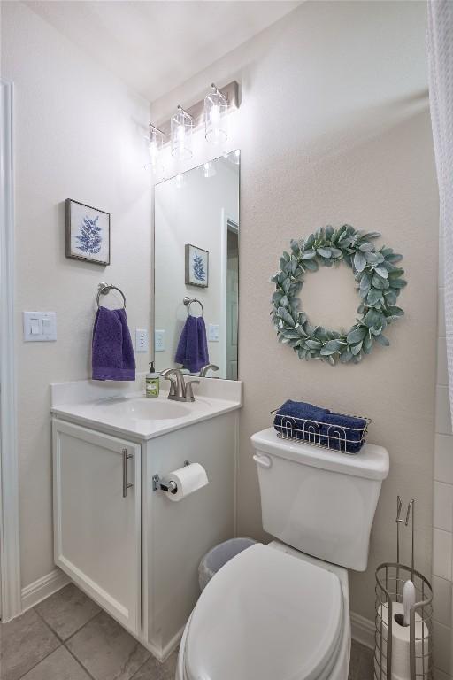 bathroom with tile patterned floors, toilet, vanity, and baseboards