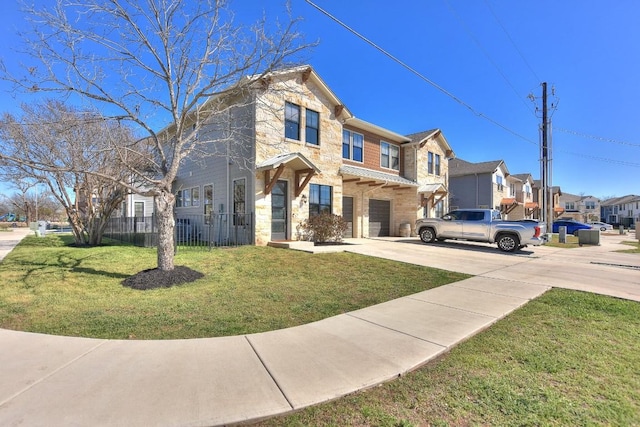 view of front facade with a front lawn, driveway, fence, a residential view, and an attached garage