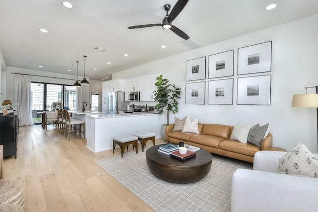 living area with recessed lighting, light wood-type flooring, visible vents, and a ceiling fan