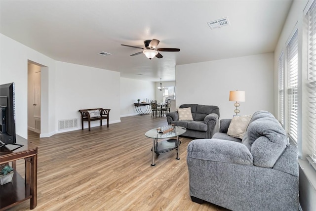 living room featuring light wood-style floors, visible vents, and a healthy amount of sunlight