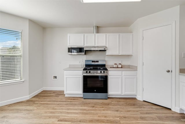 kitchen featuring white cabinetry, under cabinet range hood, light wood-type flooring, and appliances with stainless steel finishes