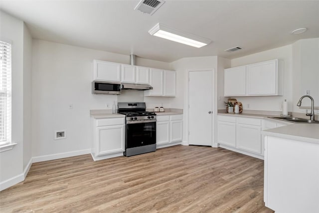 kitchen with under cabinet range hood, visible vents, stainless steel appliances, and a sink