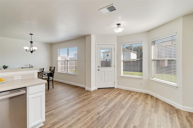 foyer entrance featuring a notable chandelier, light wood-style floors, visible vents, and baseboards