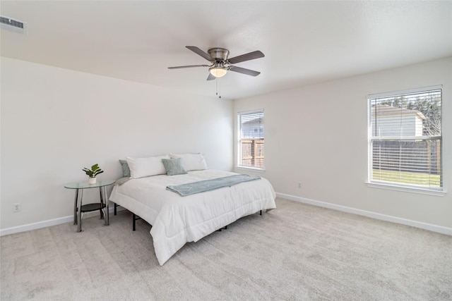 bedroom featuring visible vents, light carpet, baseboards, and ceiling fan