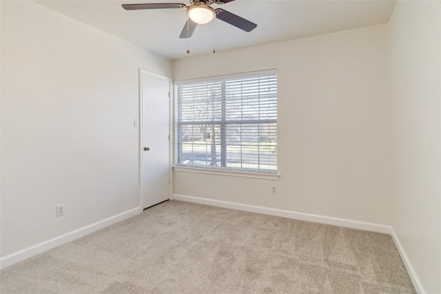 carpeted empty room with a ceiling fan and baseboards