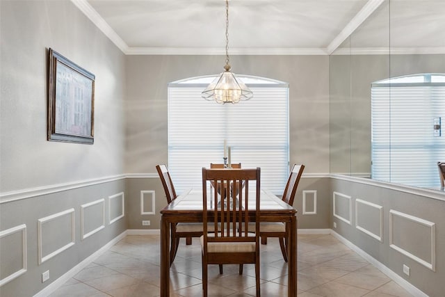 dining room with light tile patterned floors, an inviting chandelier, ornamental molding, and a decorative wall