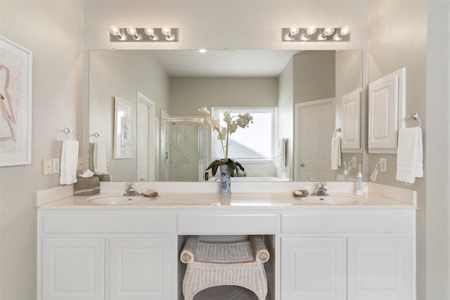 full bath with double vanity, a stall shower, and a sink