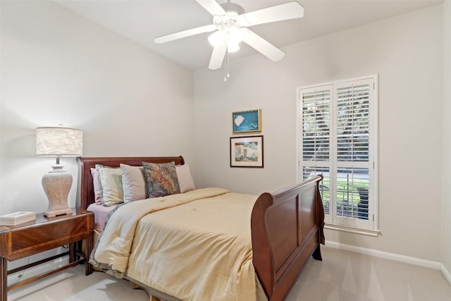 bedroom featuring light colored carpet, baseboards, and ceiling fan