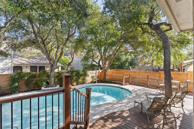 view of pool with a fenced in pool, a wooden deck, and a fenced backyard