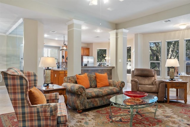 living room featuring visible vents, a healthy amount of sunlight, and decorative columns