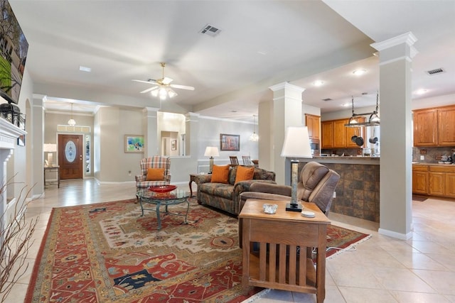 living area with visible vents, light tile patterned flooring, a ceiling fan, and ornate columns