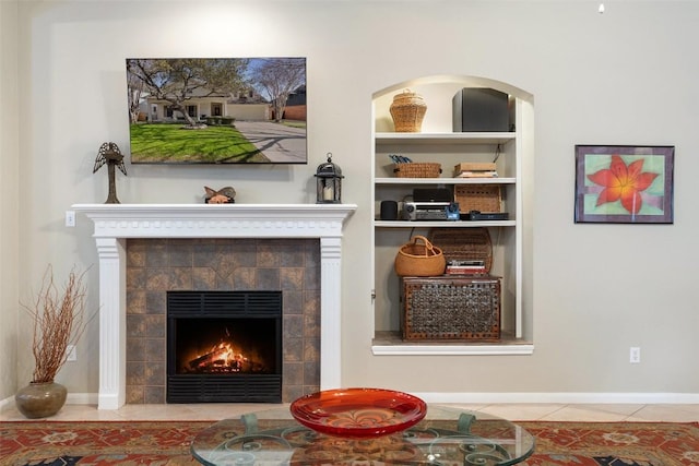 details with a tiled fireplace and baseboards