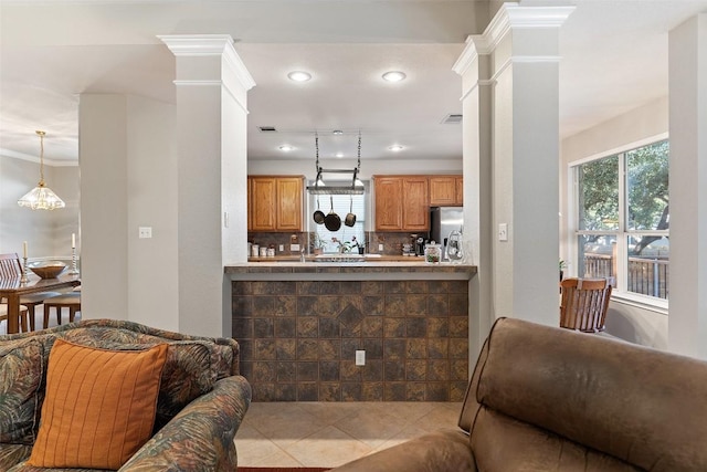 kitchen with decorative columns, stainless steel fridge with ice dispenser, visible vents, and backsplash