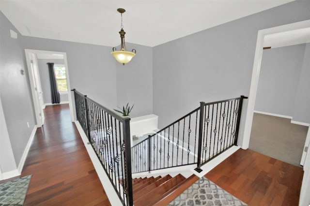 staircase with wood finished floors and baseboards