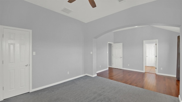 unfurnished room with wood finished floors, baseboards, lofted ceiling, arched walkways, and ceiling fan