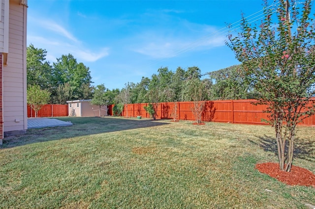 view of yard with a storage unit, an outbuilding, and a fenced backyard