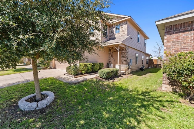 exterior space featuring a yard, concrete driveway, a garage, and fence