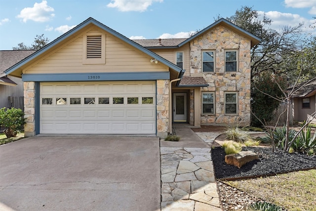 view of front of property with stone siding, driveway, and a garage