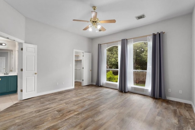 interior space featuring visible vents, baseboards, light wood-style floors, and a sink