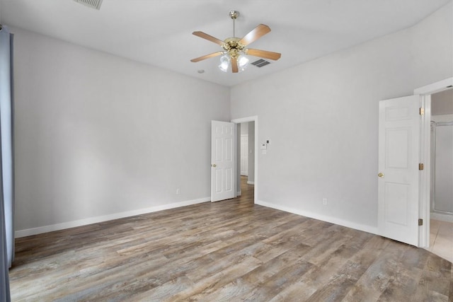 empty room featuring visible vents, baseboards, wood finished floors, and a ceiling fan