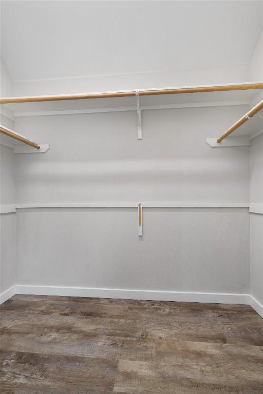 walk in closet with wood finished floors