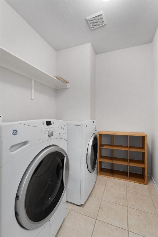 709 Stevenage Dr, Pflugerville, TX 78660 - laundry area with washing machine and dryer and light tile patterned floors