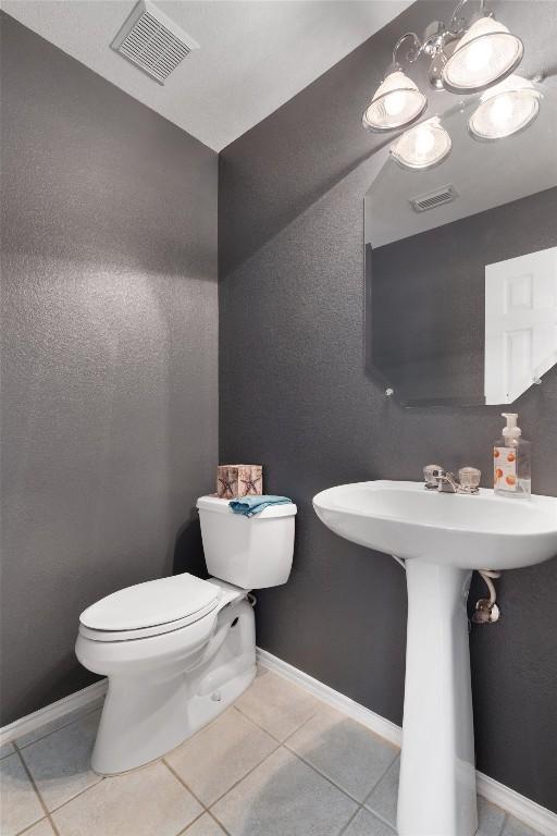 bathroom with tile patterned floors, visible vents, baseboards, and toilet