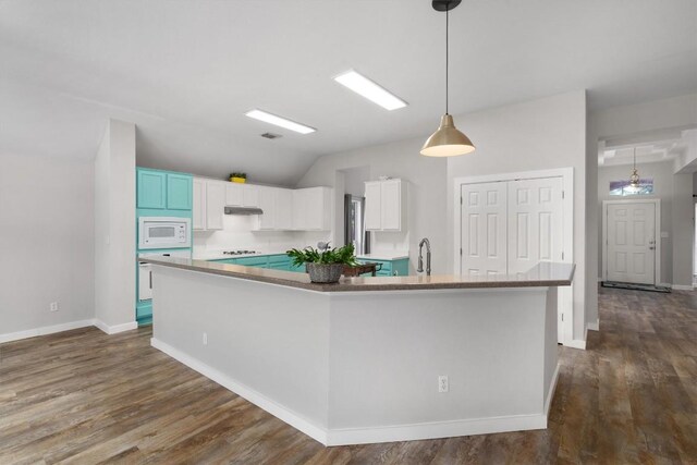 709 Stevenage Dr, Pflugerville, TX 78660 - kitchen featuring white appliances, dark wood-style floors, white cabinets, a large island with sink, and lofted ceiling