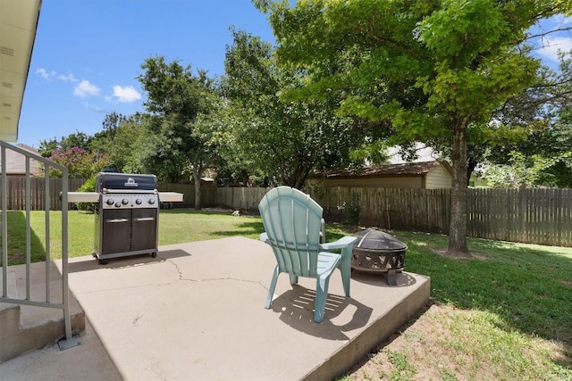 view of patio / terrace with grilling area, a fenced backyard, and an outdoor fire pit