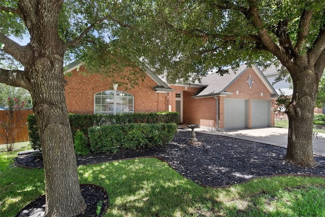 ranch-style home featuring fence, an attached garage, a shingled roof, concrete driveway, and brick siding