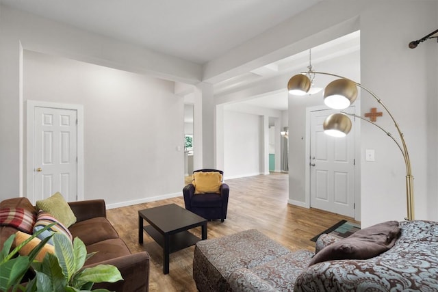 living area with baseboards and wood finished floors