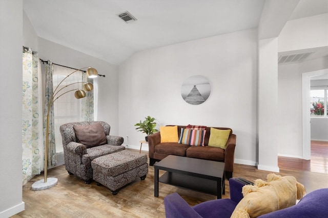 living area with visible vents, baseboards, and wood finished floors