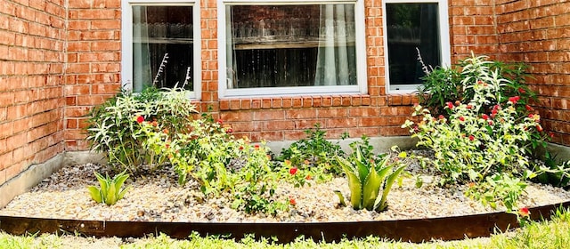 exterior details featuring brick siding and a vegetable garden