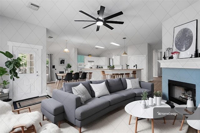 living area featuring a tiled fireplace and visible vents