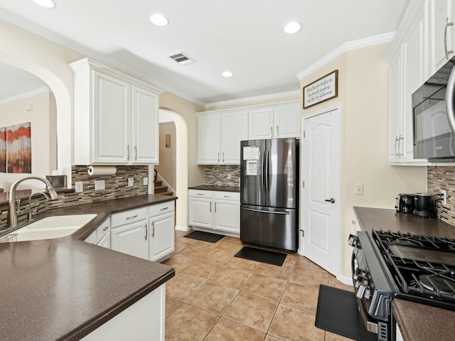 kitchen featuring a sink, visible vents, dark countertops, and freestanding refrigerator