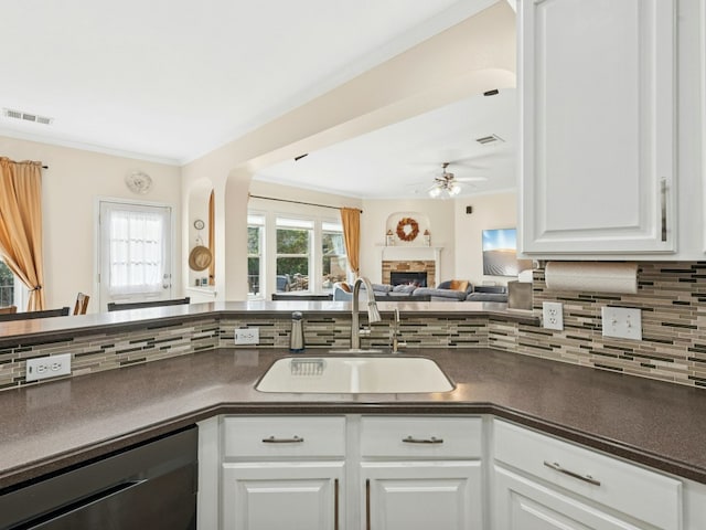 kitchen with visible vents, a lit fireplace, a sink, dishwasher, and dark countertops