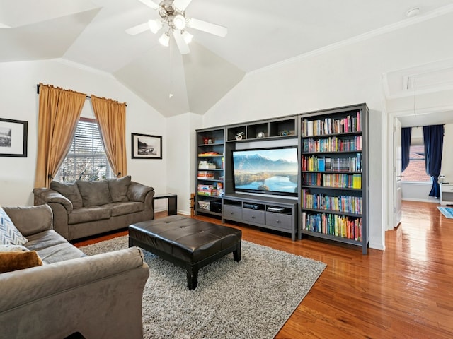 living room featuring lofted ceiling, a ceiling fan, wood finished floors, baseboards, and attic access