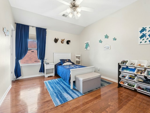 bedroom with visible vents, baseboards, lofted ceiling, and wood finished floors