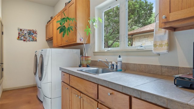 laundry area featuring washer and dryer, cabinet space, baseboards, and a sink