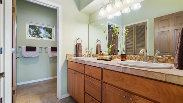 bathroom featuring tile patterned floors, backsplash, double vanity, and a sink