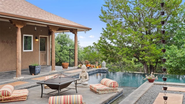 view of pool with an outdoor fire pit, an infinity pool, and a patio area