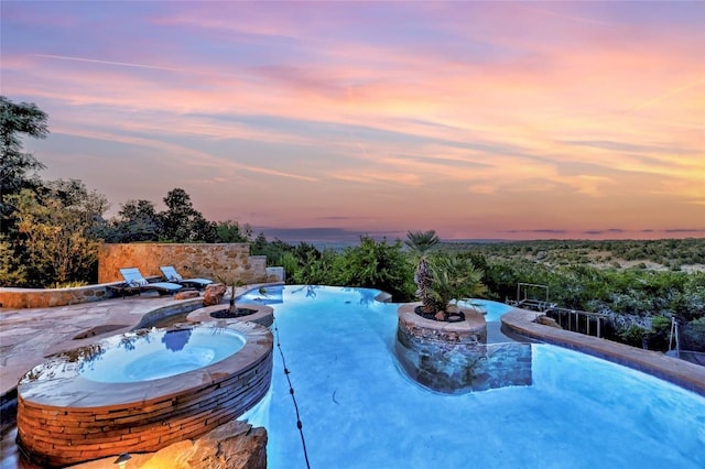 view of pool with a patio area and a pool with connected hot tub