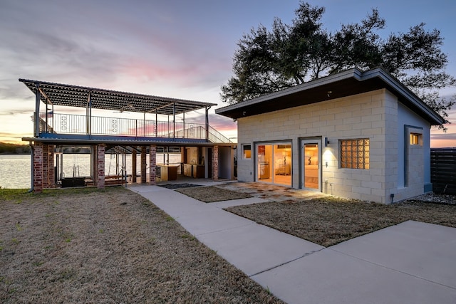 view of front of home with concrete block siding and a patio area