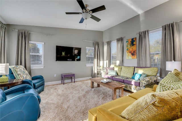 living area with baseboards, ceiling fan, and carpet floors