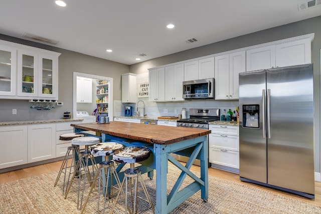 kitchen featuring visible vents, appliances with stainless steel finishes, and white cabinets