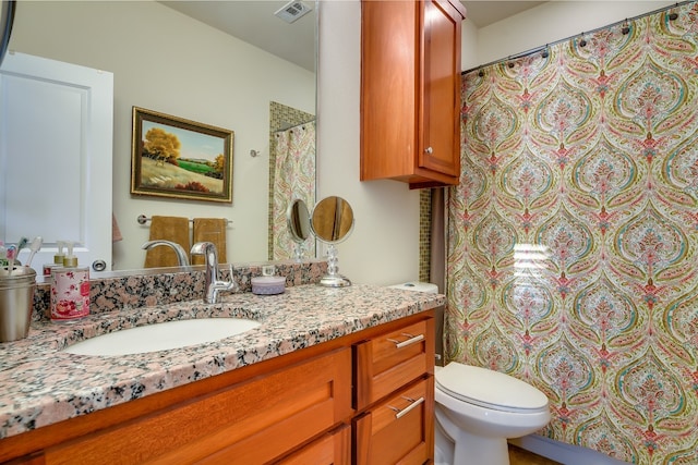 bathroom featuring visible vents, toilet, vanity, and a shower with curtain