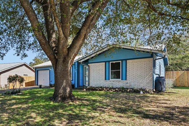 view of front of home featuring a garage, brick siding, a front yard, and fence